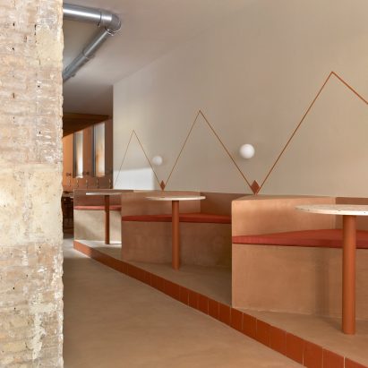 Angular seating booths and wall mural in cafe by Horma Studio
