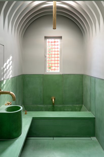 The bathroom in House Recast has a vaulted ceiling 