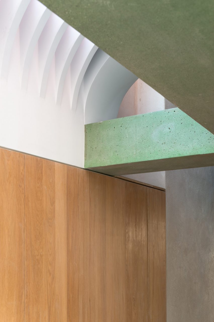 Wood panelled walls meet green concrete beams