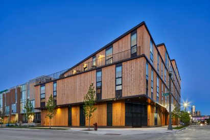 A photograph of the John R 2660 apartment building in Detroit in red-hued cedar panels