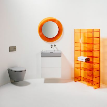 A white bathroom with orange accessories