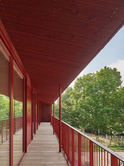 Red railings line the balcony terrace of daycare centre by Birk Heilmeyer und Frenzel Architekten