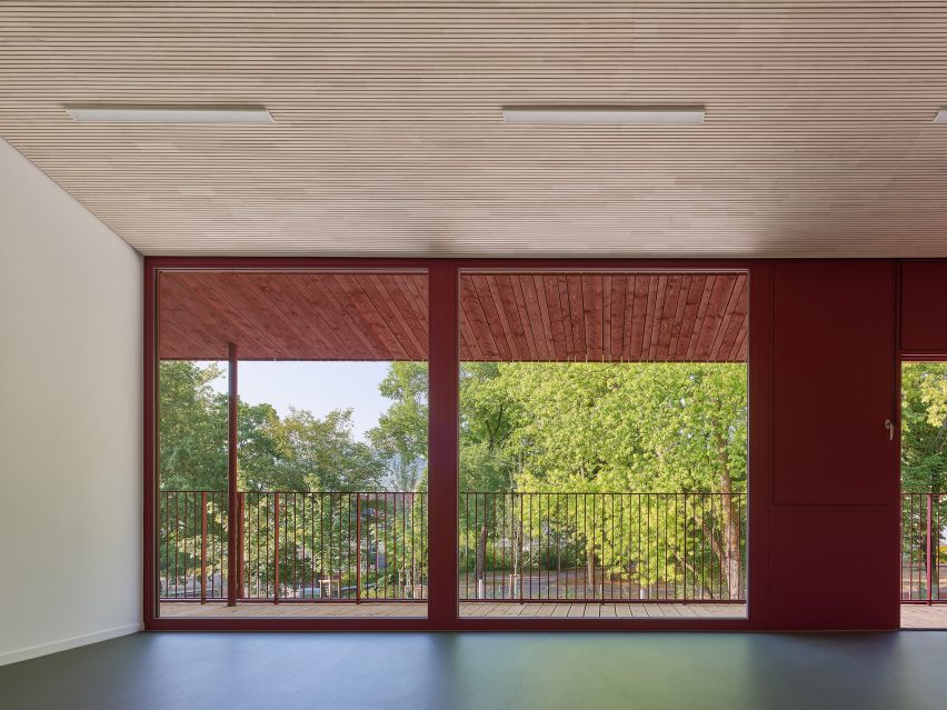 Large windows are framed by red walls