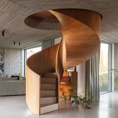A wooden spiral staircase winds through the home