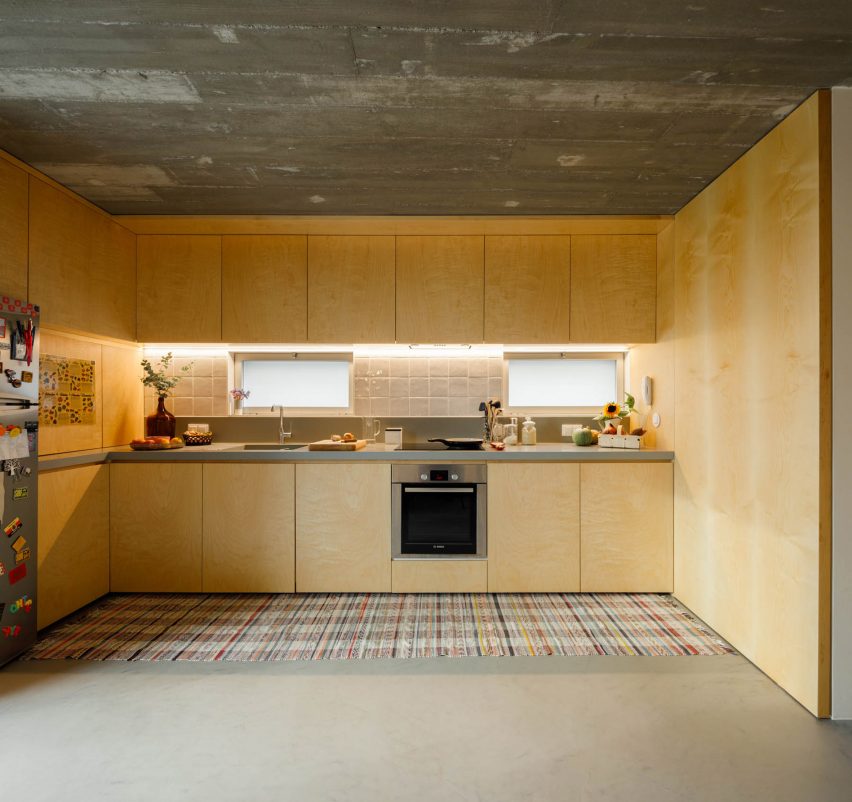 The kitchen has a light wood finish