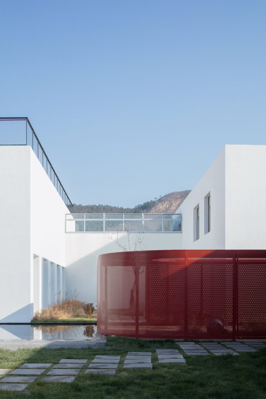 Curved red ramps that contrast with white buildings