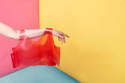 Arm holding transclucent red vest top by Valdís Steinarsdóttir
