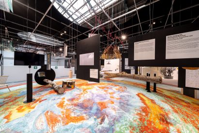 The rug has red orange and blue hues