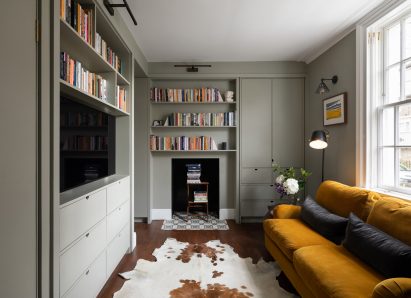 A living room with pale green cabinetry