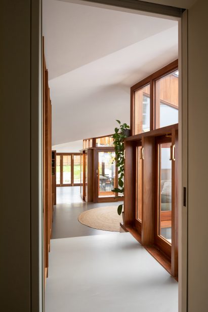 A Cloistered House's hallway with dark wood windows and doors