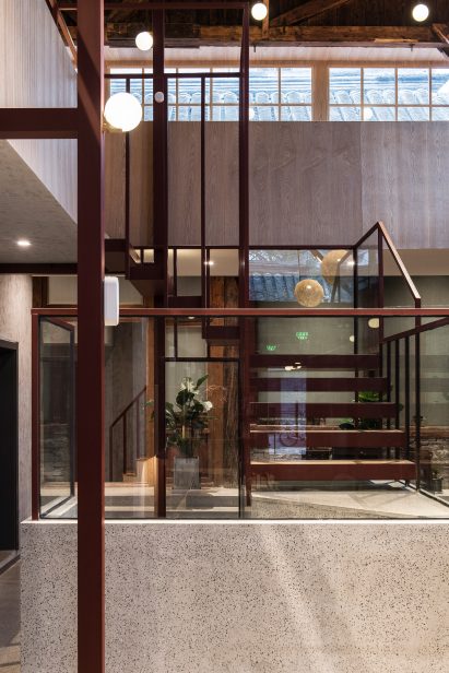 Red steel and terrazzo staircase in renovated hutong hotel by Fon Studio