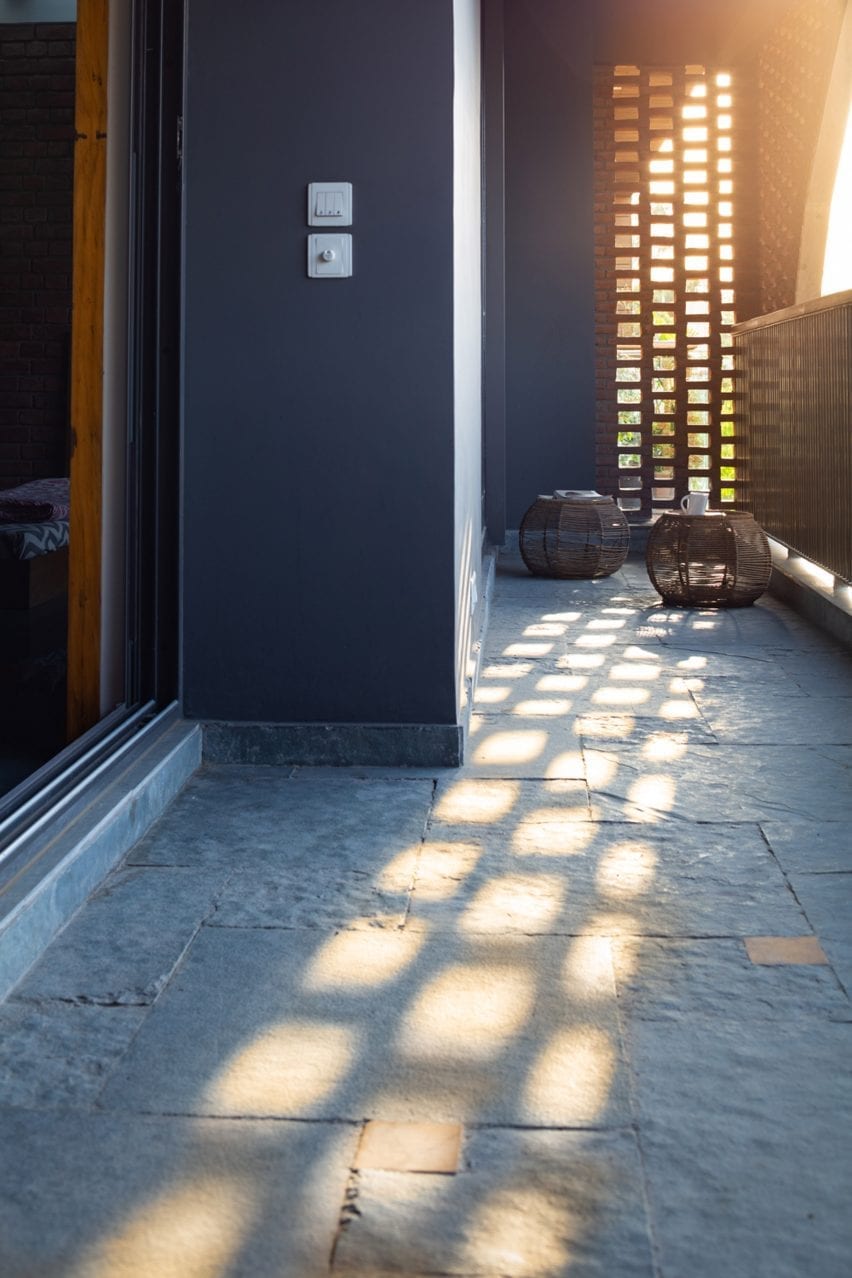 The brick screen allows light to dapple into the home