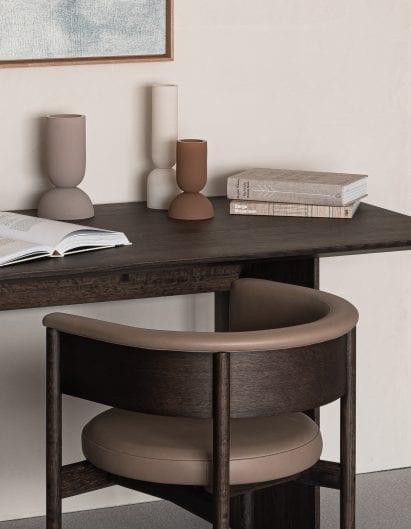 A small dark wood desk with wooden chair