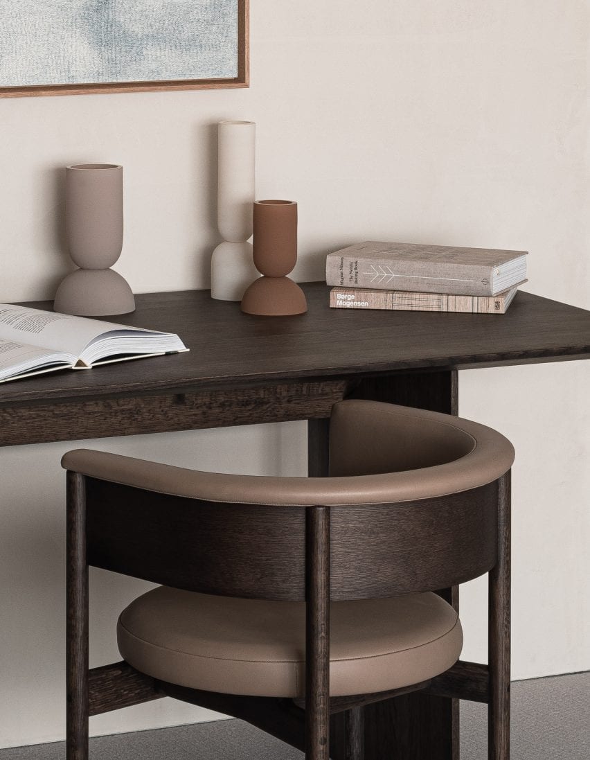 A small dark wood desk with wooden chair