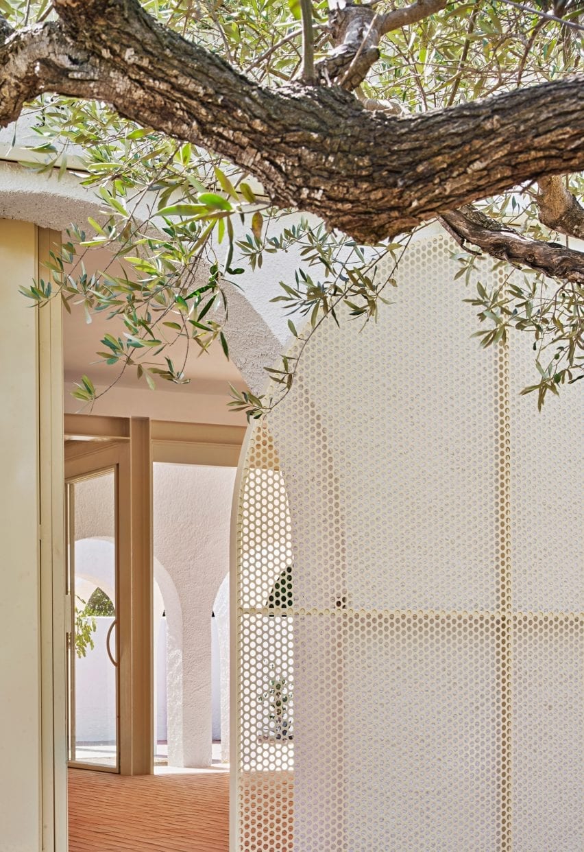 Perforated steel door reflects the shape of the arches