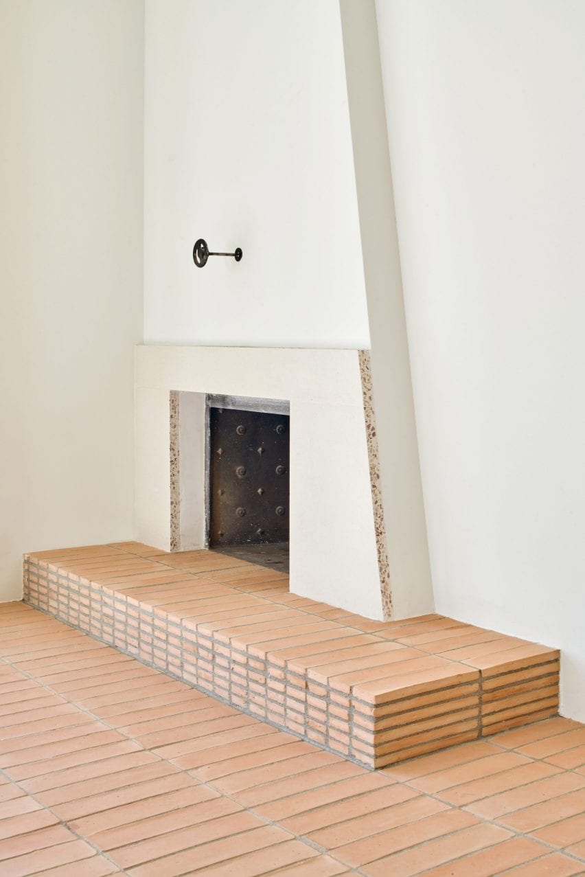 A fireplace is located atop a terracotta tiled plinth