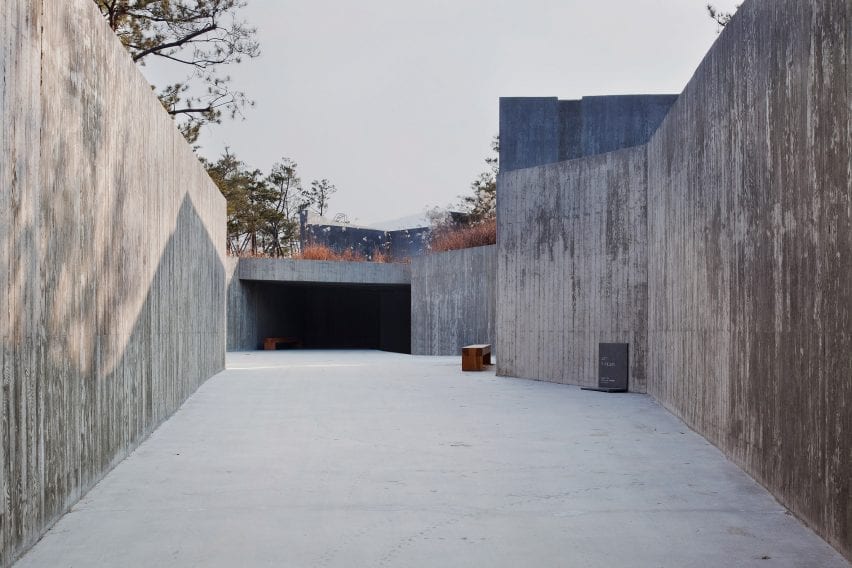 The entrance to the building is framed by retaining walls