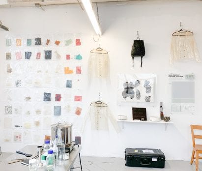 Bioplastic raincoats hanging on the wall in Charlotte McCurdy's studio