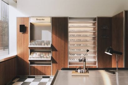Wood-panelled walls and acrylic display stands in eyewear store by Child Studio