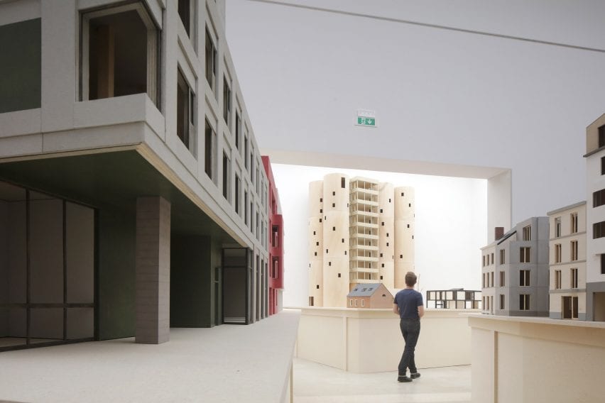 A visitor walking among architectural models