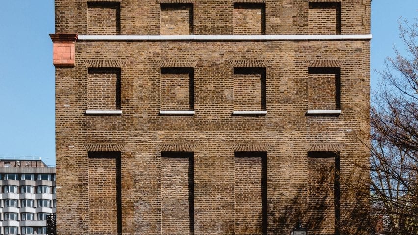 A brick facade with covered window areas