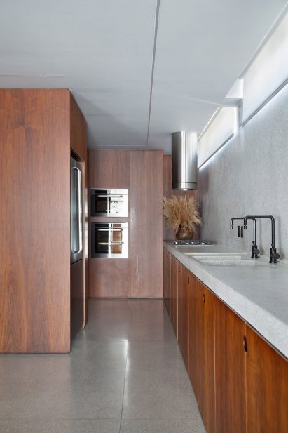 A kitchen with grey granite countertops and wooden shelving