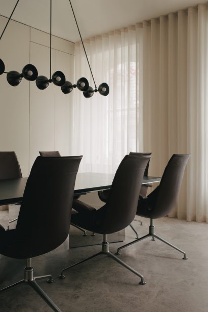 Meeting room with black chairs and large pendant lamp in Mandeville Place office