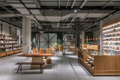 Bookshop interior by LUO Studio with wooden displays and grey floor