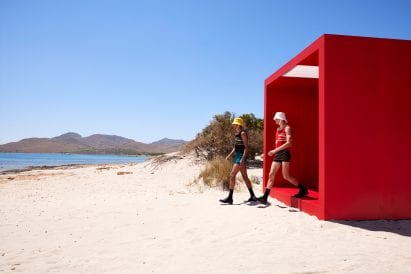 Two male models step onto beach at Prada show