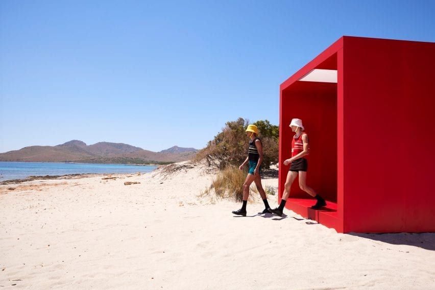 Two male models step onto beach at Prada show