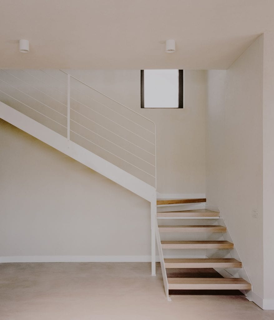A metal staircase leads to the upper floor