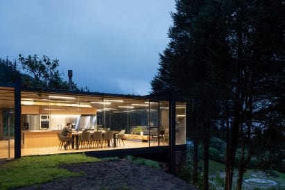 Rama Estudio has enlarged a small house in an Ecuadorian forest by adding a glass-and-metal box that extends over a hillside.