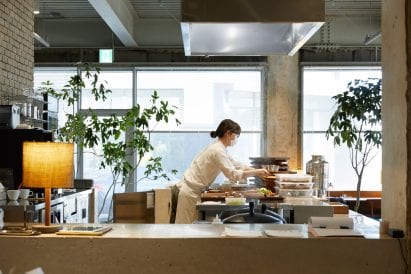 A dining space has an open kitchen at D&Department store