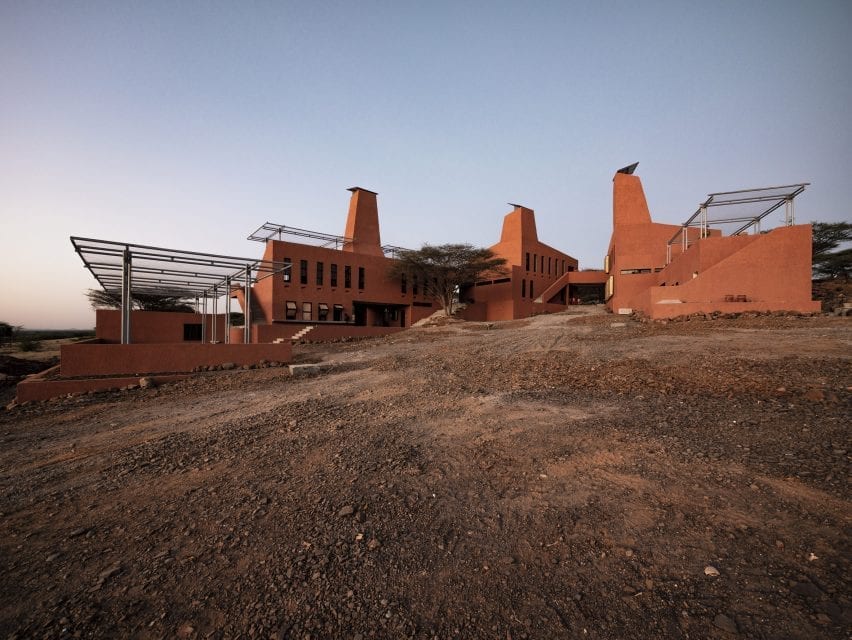 A building by Kéré Architecture covered in red plaster