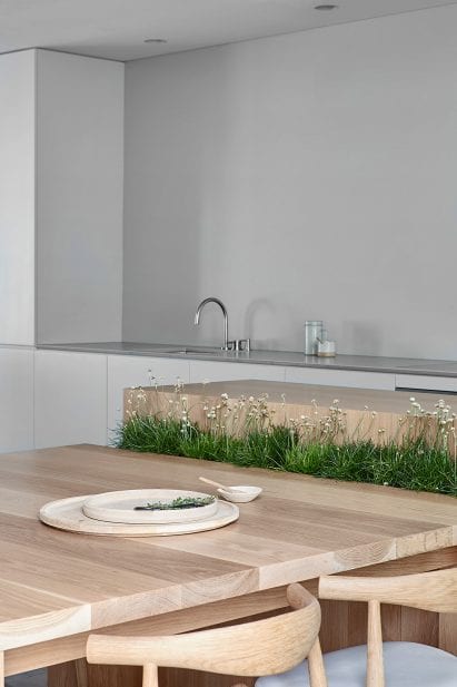 Wooden kitchen table setup with integrated planter in Cunningham Street residence