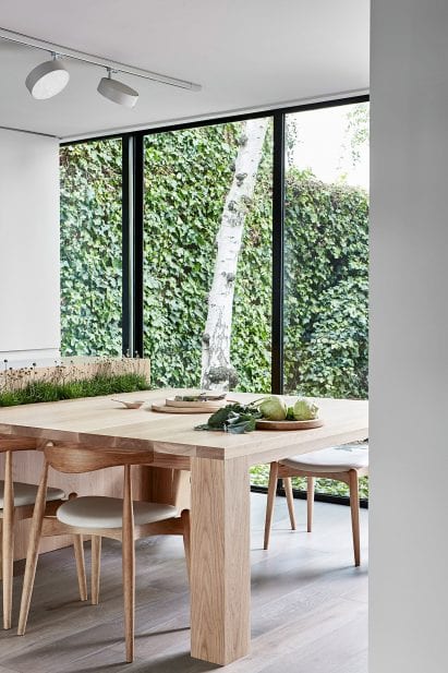Kitchen interior Studio Four with wooden chairs and table and view of garden