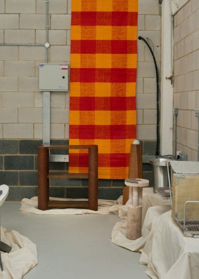 A red and orange art piece covers the brick wall at The Radford Gallery