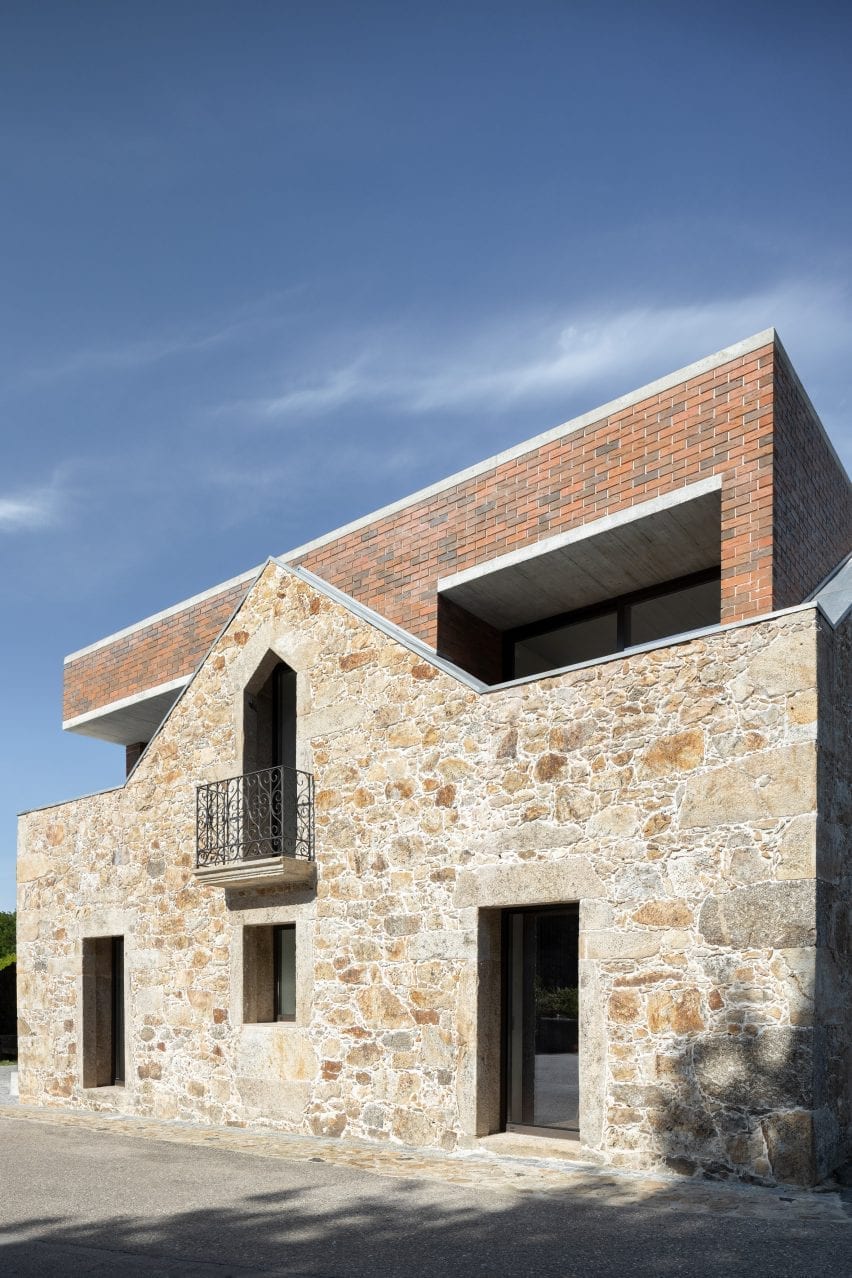 A brick extension extends above a stone wall