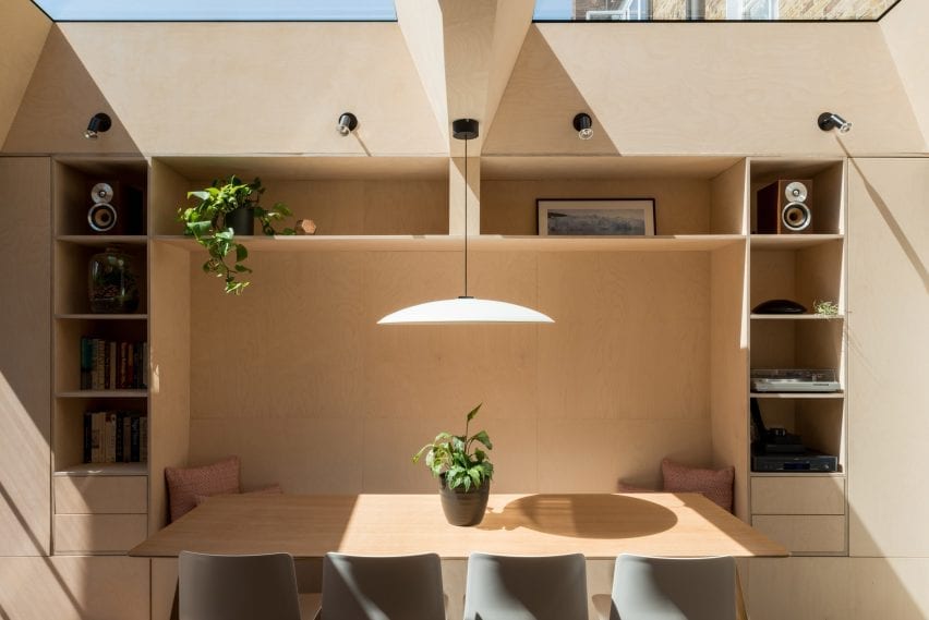 A wooden nook contains seating and storage