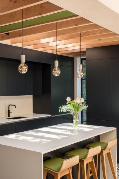 Wood beams extend over the kitchen at vault house
