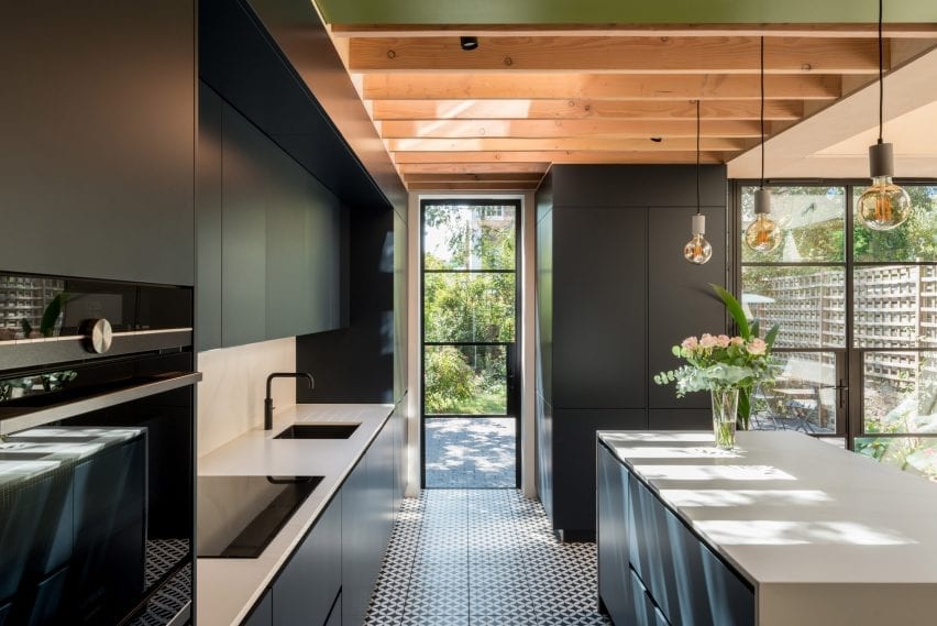 The dark cabinetry contrasts with white countertops