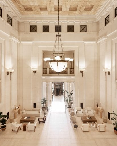 Foyer of Victoria House with chandelier and two seating areas with sofas and tables