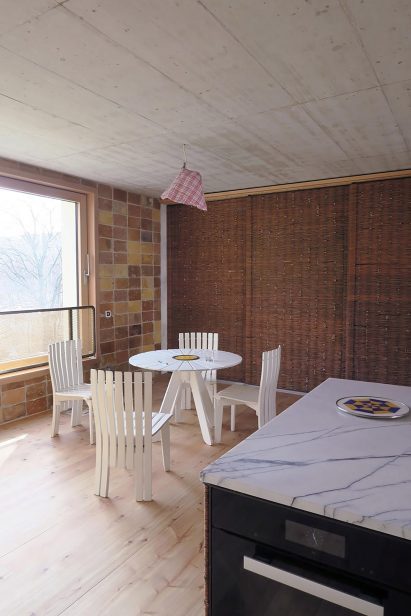 Kitchen with white seating arrangement and whicker storage wall in O12 residence