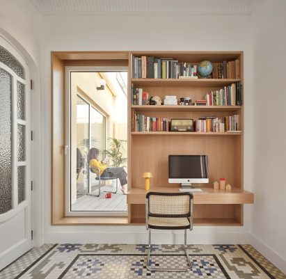 Home office with built-in wooden shelving and desk and door to terrace in Casa Cas 8