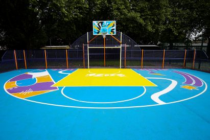 A concrete basketball court painted blue
