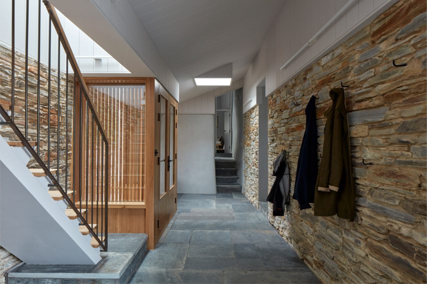 A residential hallway with a stone wall