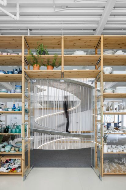 Doorway in storage wall filled with colourful ceramics in E-goi and Clavel's Kitchen by Paulo Merlini Architects