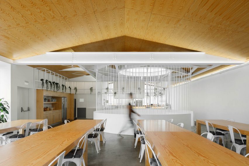 Desks and wooden ceiling on top floor of E-goi and Clavel's Kitchen by Paulo Merlini Architects
