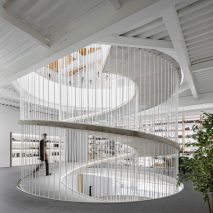 Spiralling concrete ramp in E-goi and Clavel's Kitchen by Paulo Merlini Architects