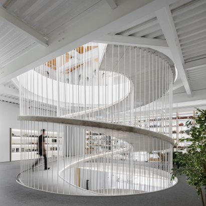 Spiralling concrete ramp in E-goi and Clavel's Kitchen by Paulo Merlini Architects
